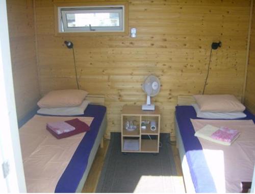 Habitación con 2 camas en una cabaña de madera en Kiige Holiday Park, en Linnamäe