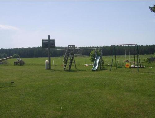 un parque infantil con un tobogán en un campo de césped en Kiige Holiday Park, en Linnamäe