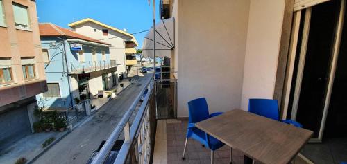 a balcony with a wooden table and blue chairs at La Lanterna in Silvi Marina