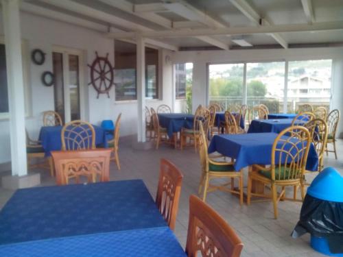 a dining room with blue tables and wooden chairs at La Lanterna in Silvi Marina