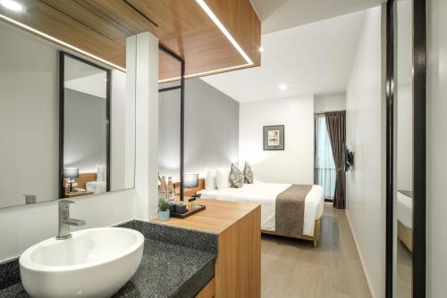 a bathroom with a sink and a bed in a room at Nap in Chiangmai in Chiang Mai