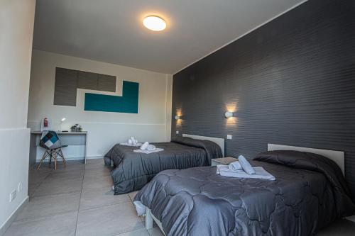 a hotel room with two beds and a table at Piano Monaco in Carini