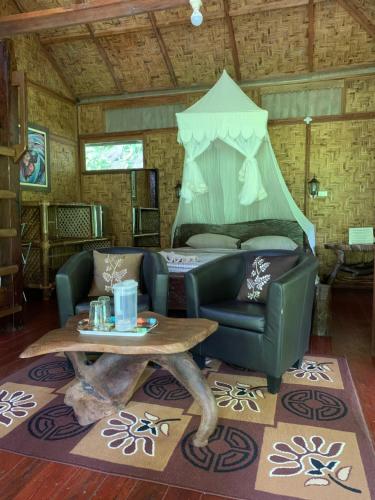 a living room with a couch and a table at Kupu Kupu Garden Guest House & Cafe in Bukit Lawang