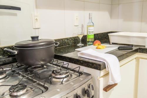 a pot on top of a stove in a kitchen at Apartamentos Breezes com verde, sossego e preço justo - ideal para famílias e amigos em Imbassaí in Imbassai