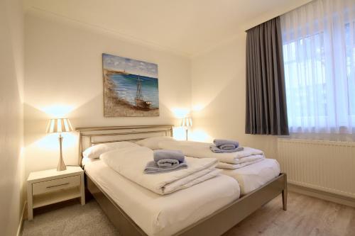 ein Schlafzimmer mit 2 Betten und Handtüchern darauf in der Unterkunft Villa Rossini Wohnung 2 in Wangerooge