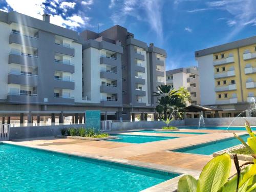 a swimming pool in front of a building at Condomínio completo em Ubatuba a 300 metros da praia in Ubatuba