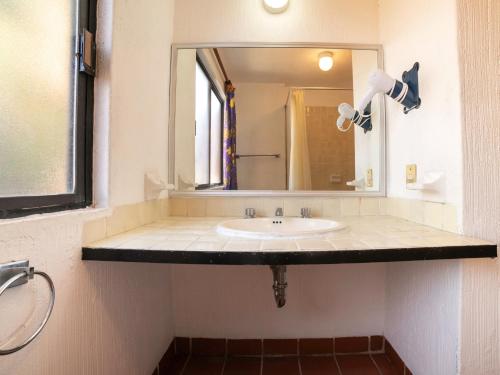 a bathroom with a sink and a mirror at Hotel La Rinconada Santa Fe in Xochitepec