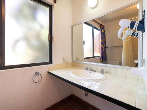 a bathroom with a sink and a mirror at Hotel La Rinconada Santa Fe in Xochitepec