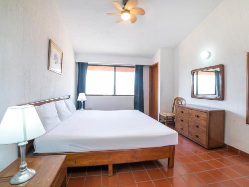 a bedroom with a bed and a lamp and a mirror at Hotel La Rinconada Santa Fe in Xochitepec