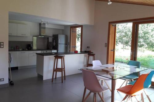 une cuisine avec une table et des chaises ainsi qu'une salle à manger dans l'établissement Gîte 