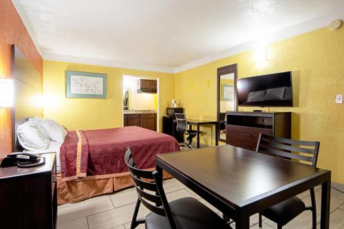 a hotel room with a bed and a table and chairs at Economy Inn & Suites in Denton