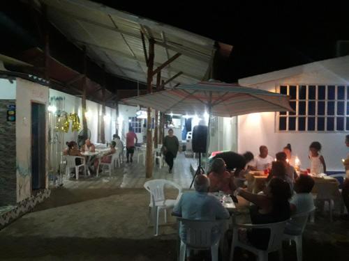 a group of people sitting at tables in a restaurant at night at Gran Muelle Hotel in San Bernardo del Viento
