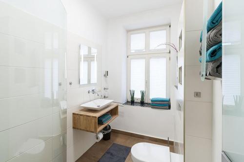 a white bathroom with a sink and a toilet at Stilvoll & ruhig - Zentrale TOP-Lage - King Bett in Leipzig