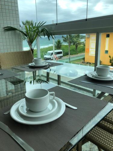Una mesa con una taza de café. en 4 ILHAS, 2 SUITES, 2 GARAGENS, en Bombinhas