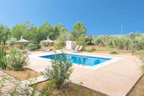 a swimming pool in a yard with two lawn chairs at Sa Cunia in Campos