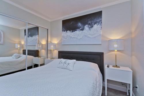 1 dormitorio blanco con 2 camas y 2 lámparas en Fun and Functional Waterfront Condo - Heated Pool - WIFI en Tampa