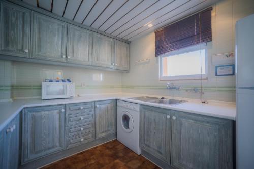 a kitchen with a sink and a microwave at Marina Plaza by Garvetur in Vilamoura