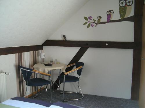 a room with a table and chairs in a attic at Pension an der Havel in Havelberg