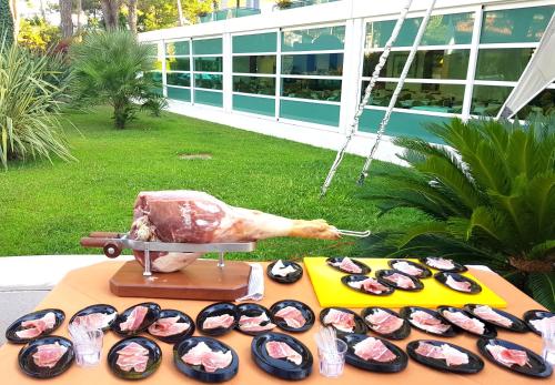 a table topped with sushi and a statue of a cow at Hotel Mediterraneo in Lignano Sabbiadoro