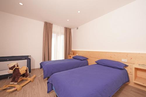 a room with two beds and a chair in it at Agriturismo Hegemone in Tremosine Sul Garda