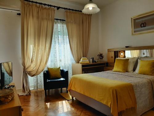 a bedroom with a bed and a window and a chair at Mary Apartments in Almada