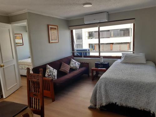 - une chambre avec un lit, un canapé et une fenêtre dans l'établissement Isabel Suites Vitacura, à Santiago