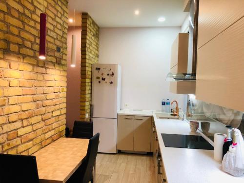 a kitchen with a table and a brick wall at Karlsons apartment in Liepāja