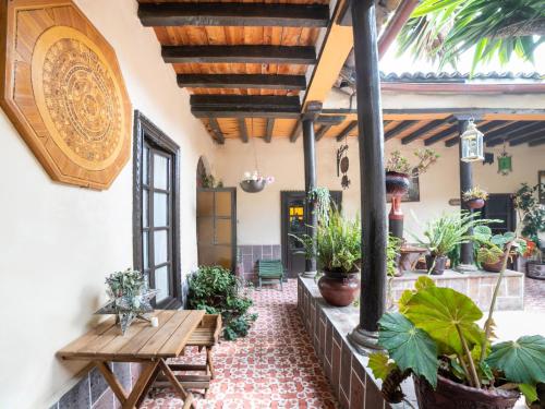 an outdoor patio with a wooden table and potted plants at Hotel del Carmen in Tlalpujahua de Rayón