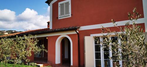 a red and white house with an arch doorway at B&B Luna Nuova in Sarzana