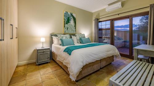 マレラネにあるNkomazi Kruger Lodge & Spaのベッドルーム1室(ベッド1台、テーブル、窓付)