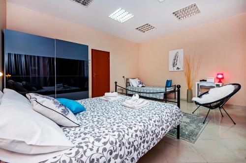 a bedroom with a bed and a chair at Rovinj City Apartment in Rovinj