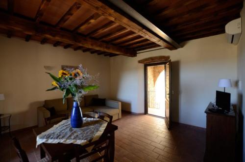 a living room with a vase of flowers on a table at Antico Borgo Casalappi in Campiglia Marittima