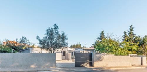 a house with a retaining wall and a fence at eVita Fazana Premium Studio Apartments in Fažana