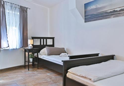 1 Schlafzimmer mit 2 Betten, einem Tisch und einem Fenster in der Unterkunft Hotel Frankenthaler Hof in Frankenthal