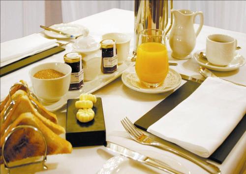 a table with breakfast foods and orange juice on it at Glen-Yr-Afon House Hotel in Usk