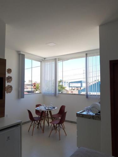 cocina con mesa, sillas y ventanas en Apartamento de Luxo, en Prado