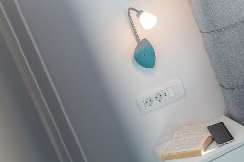 a lamp on a wall with a book and a lightswitch at eVita Fazana Premium Studio Apartments in Fažana