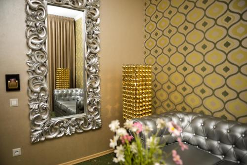 a living room with a leather couch and a mirror at Weekend Boutique Hotel in Chişinău