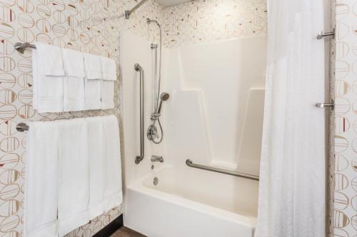 bagno con vasca, doccia e asciugamani bianchi di Holiday Inn Philadelphia South-Swedesboro, an IHG Hotel a Swedesboro