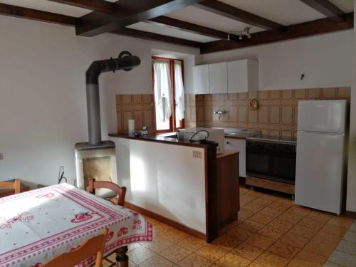 uma cozinha com um fogão e um frigorífico branco em Il Puntone em Fiumalbo