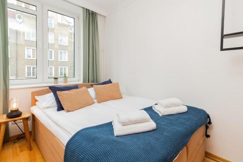 a bedroom with a large bed with a window at Apartament Old City Center Gdańsk by Renters in Gdańsk