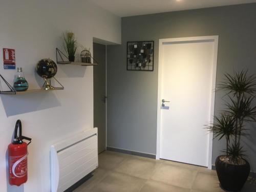 a room with a white door and a plant at L'échappée Saline in Saint-Molf
