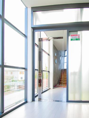 an open glass door of a building with a staircase at Hotel Marina in Marina di Massa