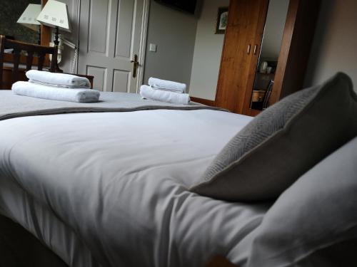 1 Schlafzimmer mit 2 Betten mit weißer Bettwäsche und Kissen in der Unterkunft Glen Gat House in Dundalk
