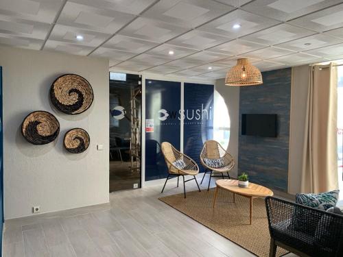 a lobby with chairs and a table and a tv at Apartamentos Guadiana in Monte Gordo