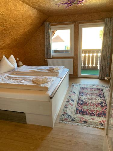 a bedroom with a bed and a window and a rug at Seerestaurant & Suiten Hayat in Steindorf am Ossiacher See