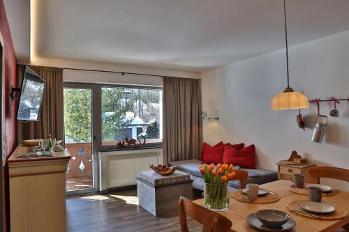 ein Wohnzimmer mit einem Tisch und einem Sofa in der Unterkunft Das Schönanger Ferienwohnungen in Grainau