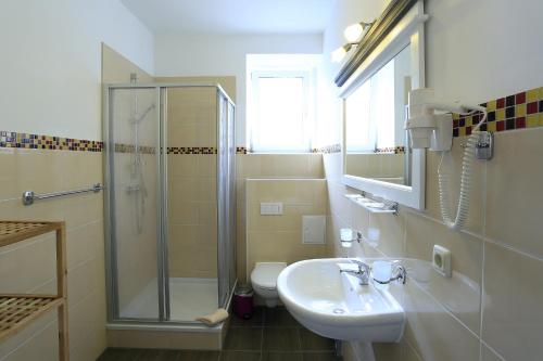 a bathroom with a sink and a shower and a toilet at Landhotel & Brauhaus Prignitzer Hof in Pritzwalk