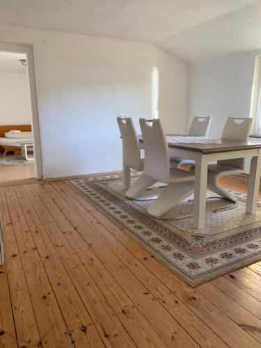 ein Esszimmer mit einem Tisch und weißen Stühlen in der Unterkunft Seerestaurant & Suiten Hayat in Steindorf am Ossiacher See