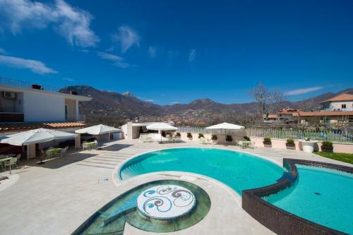 a swimming pool in a resort with mountains in the background at Hotel le Rocce - Agerola, Amalfi Coast in Agerola